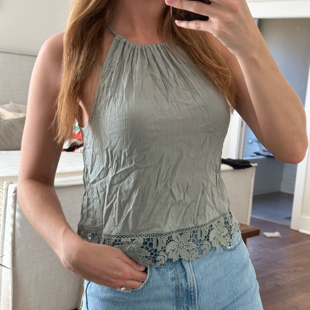 Sage green tunic tank top with floral lace detail at the bottom.